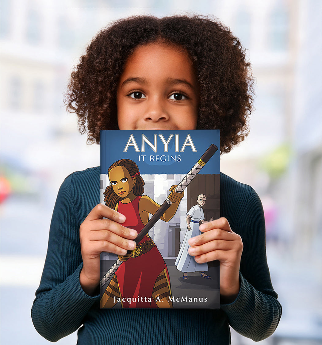 Child holding a middle grade fantasy book titled 'ANYIA IT BEGINS' by Jacquitta A. McManus